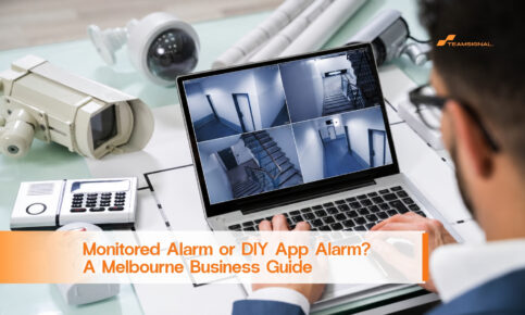 Security professional reviews CCTV feeds on a laptop beside alarm equipment and a floor plan.