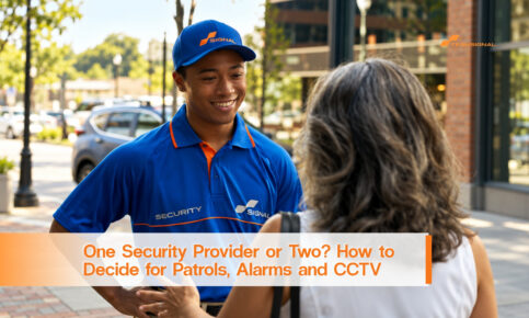 A smiling Signal security officer speaks with a woman outside a commercial building.